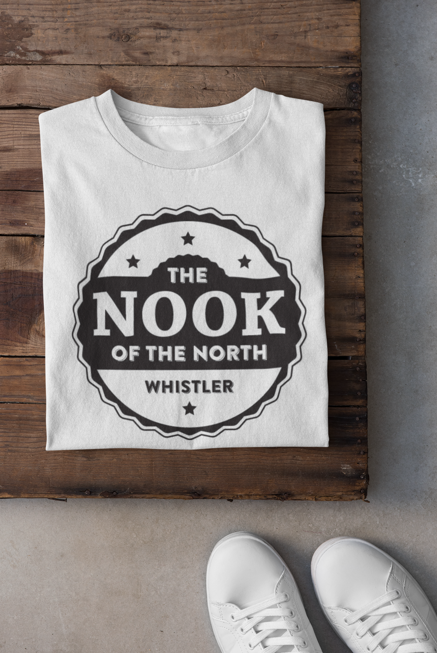 Folded white T-shirt with Nook of the North logo – custom printing sample